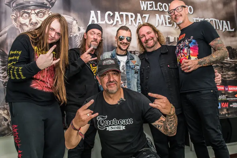 Backstage meet and greet in front of a festival wall